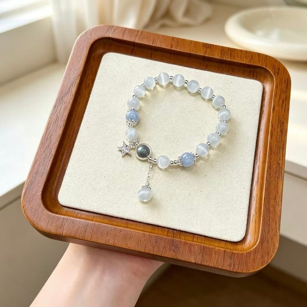 Cat’s eye aquamarine bracelet held in hand