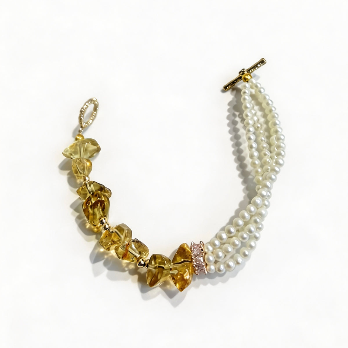 Side view of a multi-strand pearl bracelet with citrine stones and vintage-inspired toggle clasp