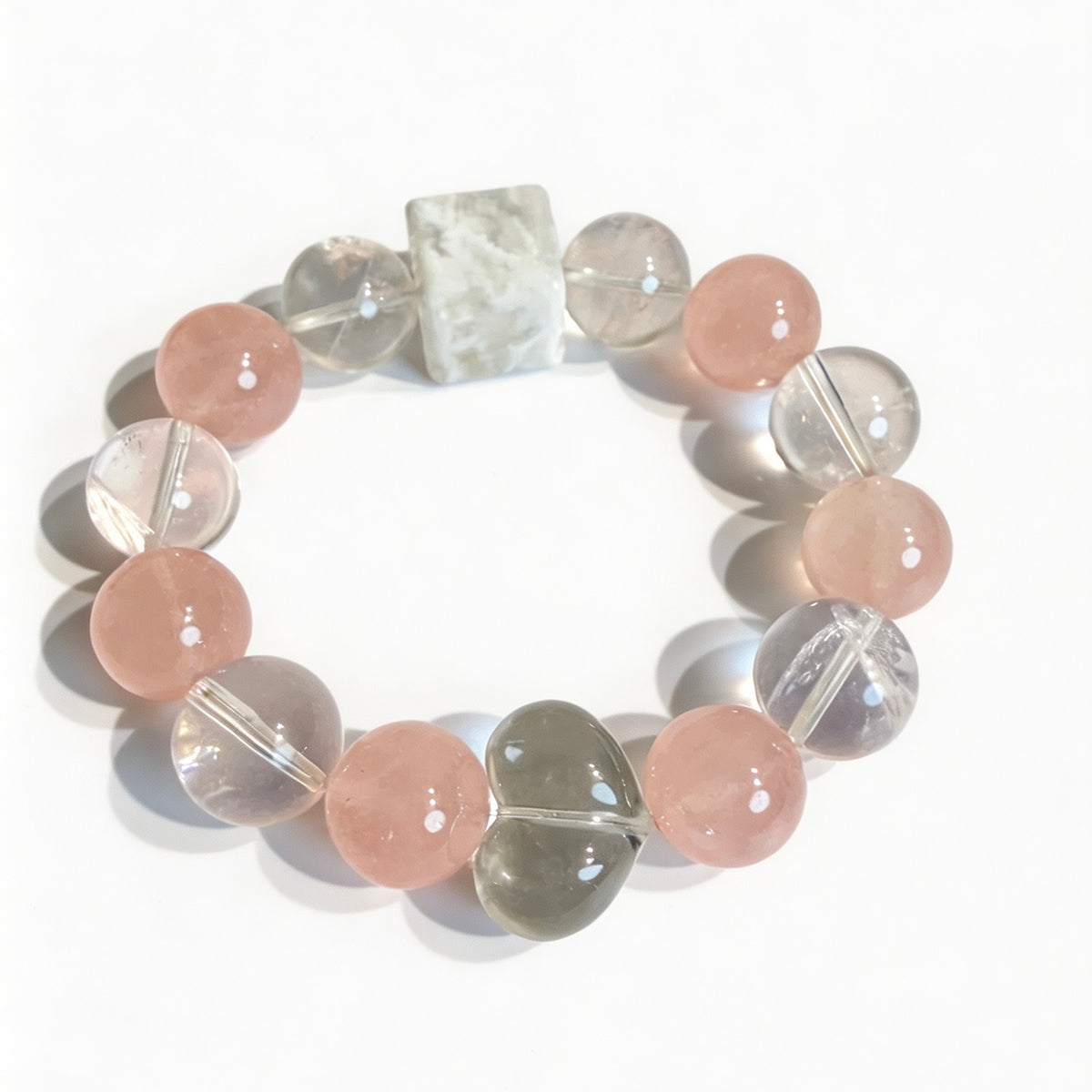 Close-up of pink rose quartz and clear quartz beads on a crystal bracelet