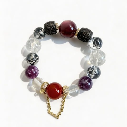 Multi crystal bracelet with a red agate focal bead, purple gemstone beads, clear quartz, and gold-tone chain